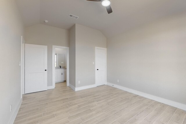 unfurnished bedroom with baseboards, light wood-type flooring, and lofted ceiling