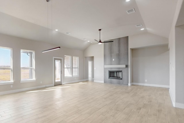 unfurnished living room with a large fireplace, light wood-style floors, a healthy amount of sunlight, and ceiling fan