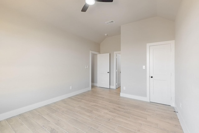 unfurnished bedroom featuring visible vents, baseboards, lofted ceiling, light wood-style flooring, and a ceiling fan