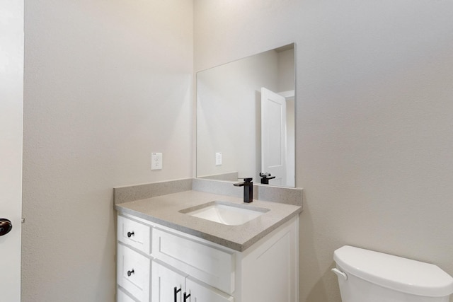 half bath featuring toilet and vanity