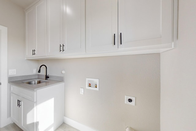 laundry room with electric dryer hookup, washer hookup, cabinet space, and a sink