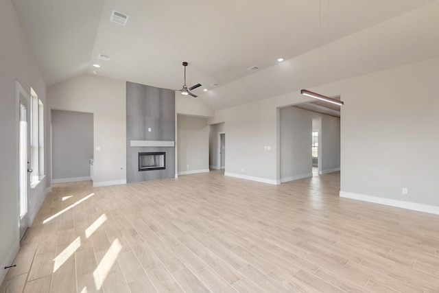 unfurnished living room with visible vents, a large fireplace, baseboards, ceiling fan, and light wood-style flooring