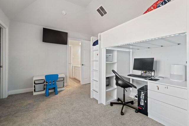 carpeted office space with baseboards, visible vents, and vaulted ceiling