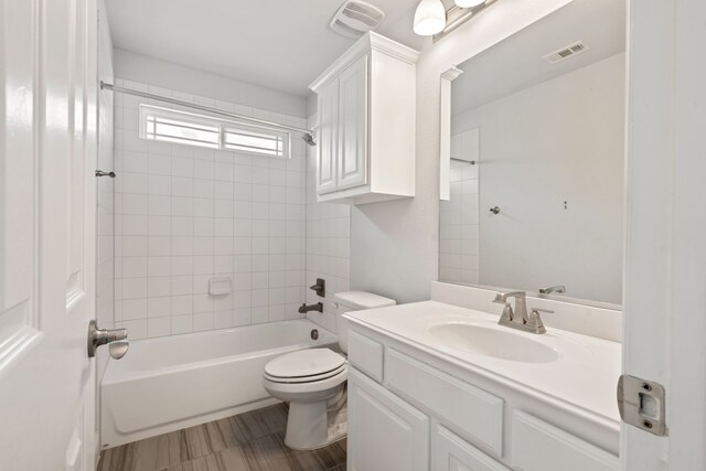 bathroom with toilet, bathing tub / shower combination, visible vents, and vanity