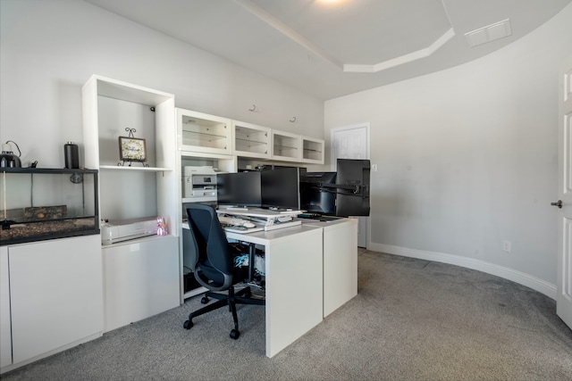 home office with baseboards, a tray ceiling, and light colored carpet