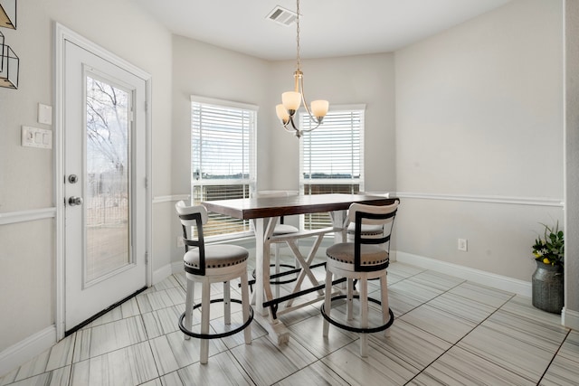 dining area featuring a chandelier, visible vents, and baseboards