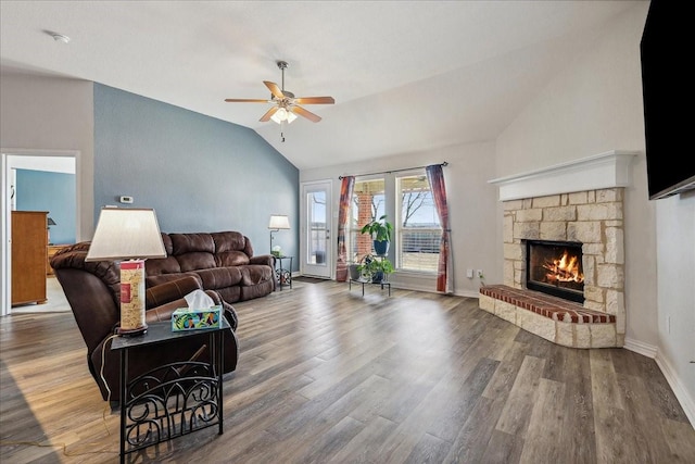 living area with wood finished floors, baseboards, lofted ceiling, a fireplace, and ceiling fan