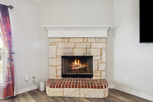 interior details featuring wood finished floors, a fireplace, and baseboards