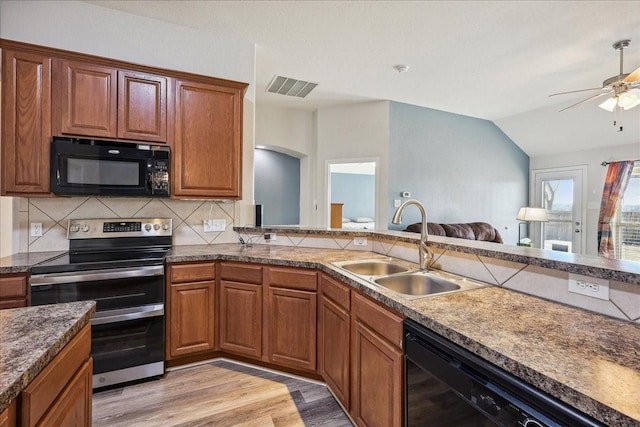 kitchen with visible vents, light wood-type flooring, black appliances, a sink, and tasteful backsplash