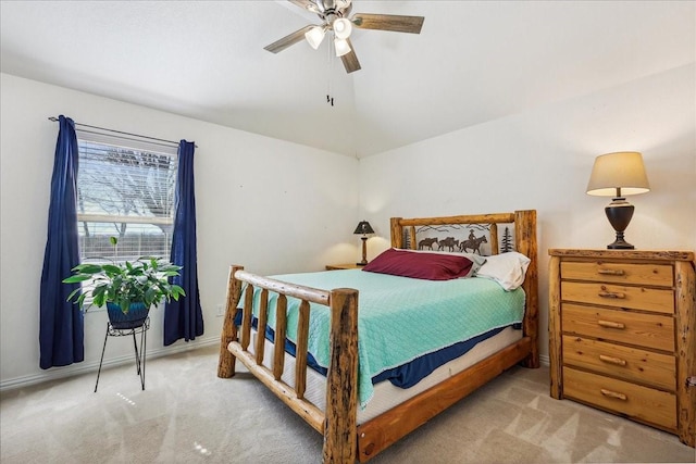 carpeted bedroom with vaulted ceiling, a ceiling fan, and baseboards