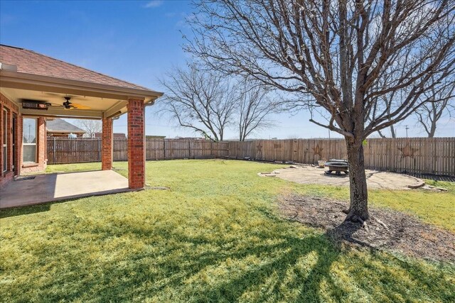 view of yard with a fenced backyard, a patio, a fire pit, and ceiling fan