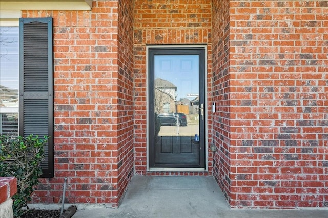 entrance to property featuring brick siding