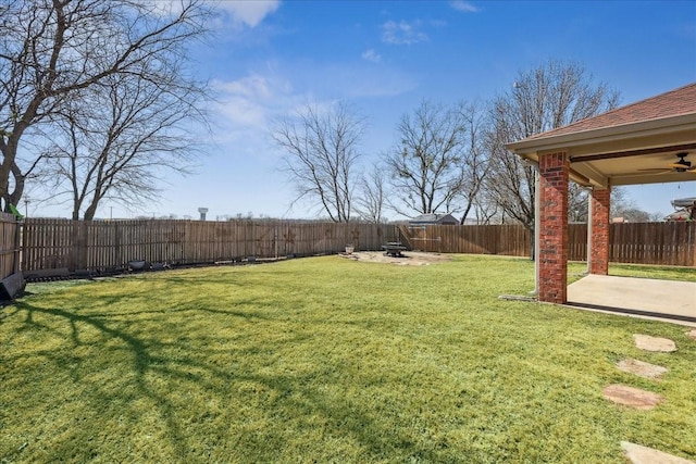 view of yard with a patio area, ceiling fan, an outdoor fire pit, and a fenced backyard