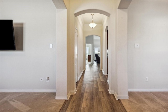 hall with arched walkways and baseboards