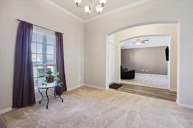 interior space with crown molding, carpet flooring, baseboards, and arched walkways