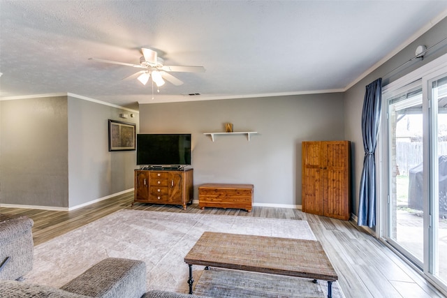 living area with light wood-type flooring, crown molding, and baseboards