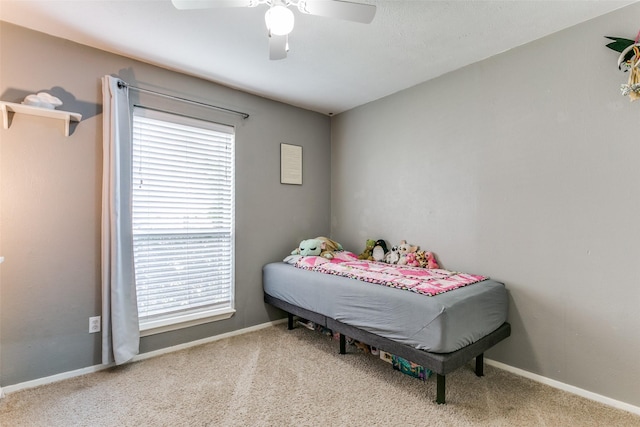 carpeted bedroom featuring baseboards and a ceiling fan