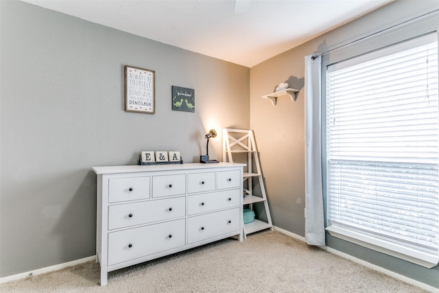 bedroom featuring light carpet and baseboards