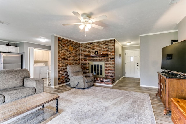 living room featuring visible vents, baseboards, a ceiling fan, light wood-style flooring, and a brick fireplace