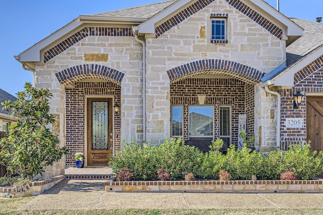 view of front of property featuring brick siding and stone siding