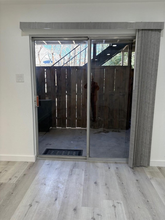 entryway featuring baseboards and wood finished floors