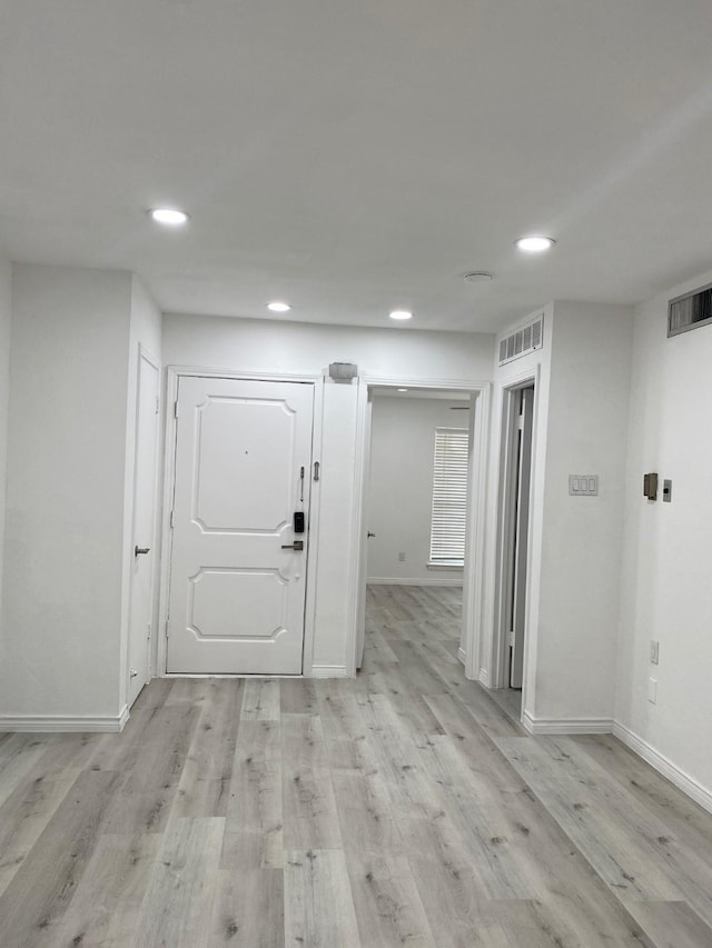 foyer entrance featuring baseboards, light wood-type flooring, visible vents, and recessed lighting