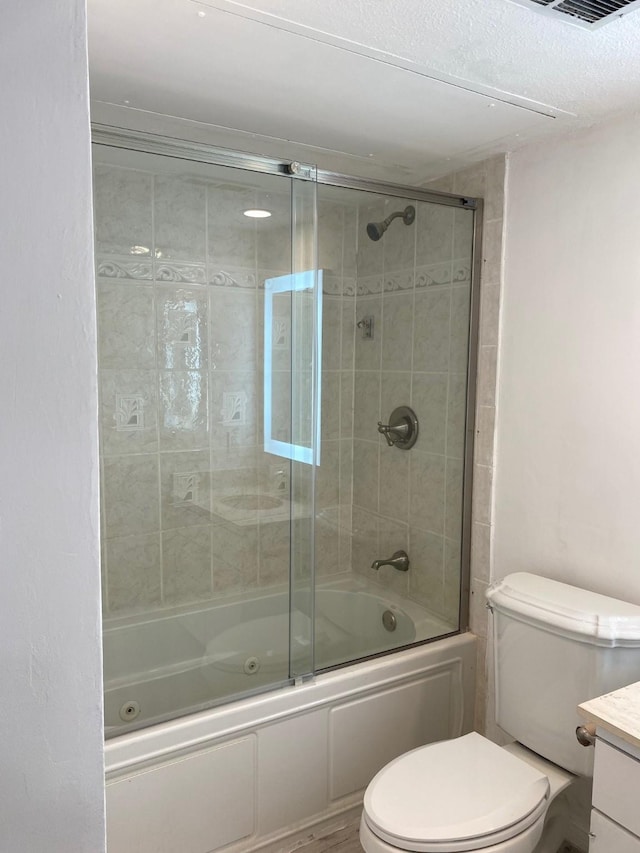 bathroom with toilet, visible vents, combined bath / shower with glass door, and vanity