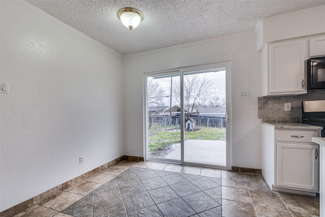 unfurnished dining area featuring a textured ceiling, baseboards, and a textured wall