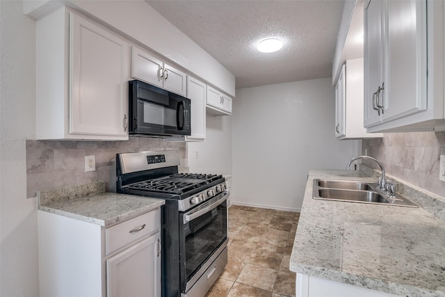 kitchen featuring stainless steel gas stove, a sink, a textured ceiling, white cabinetry, and black microwave