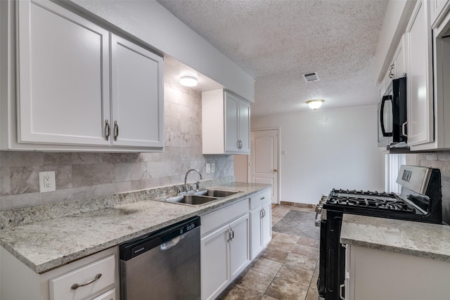 kitchen featuring visible vents, backsplash, stainless steel appliances, white cabinetry, and a sink