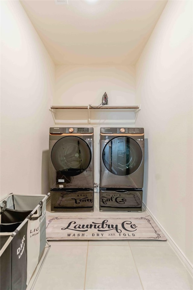 laundry area featuring laundry area, baseboards, washer and dryer, and tile patterned floors