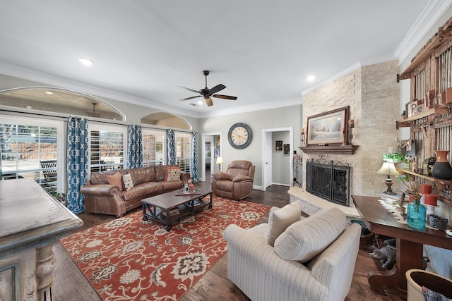 living area featuring ceiling fan, recessed lighting, dark wood-type flooring, a fireplace, and crown molding