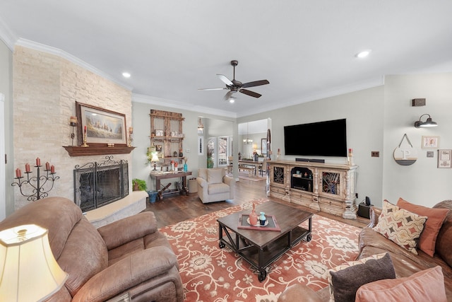 living area with ceiling fan, recessed lighting, a fireplace, wood finished floors, and ornamental molding