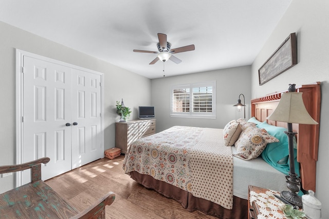 bedroom with a closet, wood finished floors, and a ceiling fan