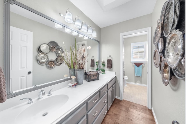 full bathroom featuring vanity, wood finished floors, toilet, and baseboards