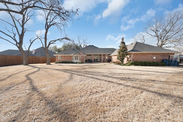 ranch-style home with brick siding and fence