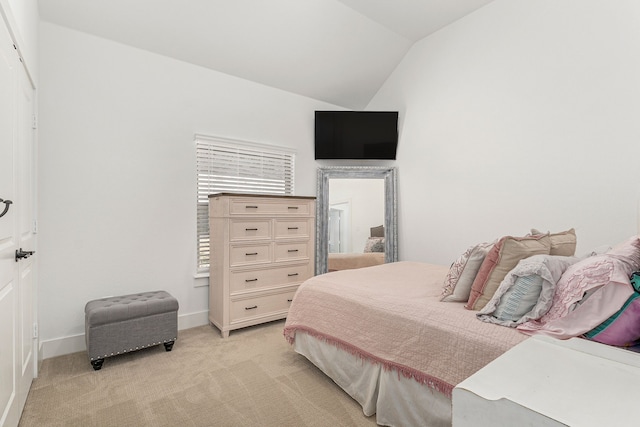 bedroom featuring lofted ceiling, light carpet, and baseboards