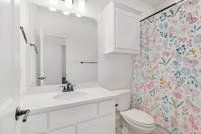 full bathroom featuring a shower with shower curtain, vanity, and toilet