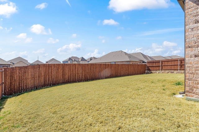 view of yard featuring a fenced backyard and a residential view