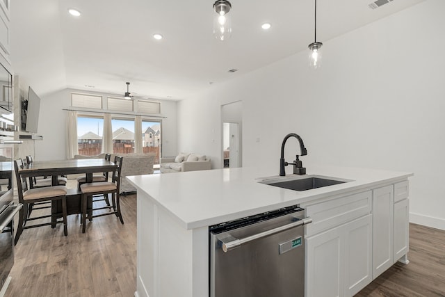 kitchen with stainless steel dishwasher, white cabinets, a sink, an island with sink, and wood finished floors