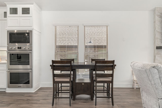 dining space featuring dark wood finished floors and baseboards