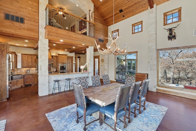 dining area featuring visible vents, wooden ceiling, concrete floors, and an inviting chandelier