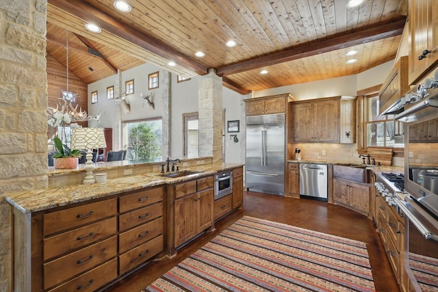 kitchen featuring beam ceiling, decorative backsplash, brown cabinets, stainless steel appliances, and a sink