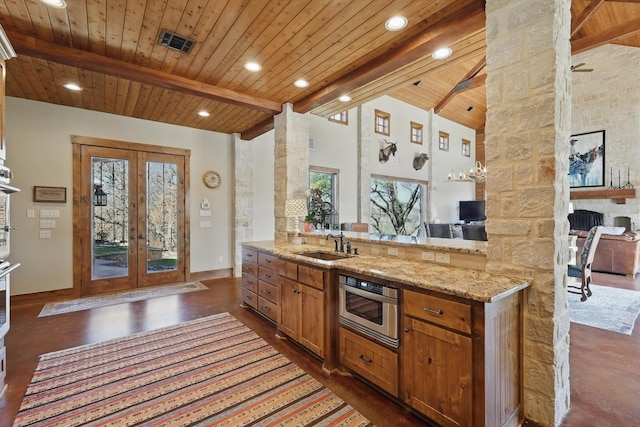 kitchen with visible vents, beam ceiling, a sink, wood ceiling, and french doors