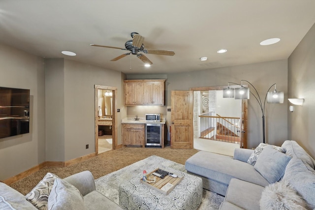 living area featuring light carpet, beverage cooler, recessed lighting, baseboards, and ceiling fan