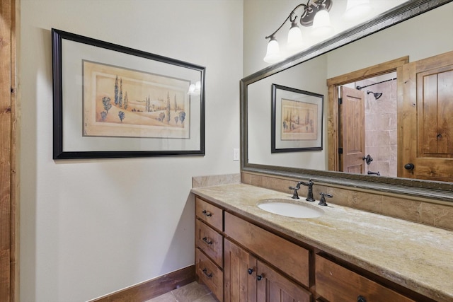 bathroom with vanity, baseboards, and walk in shower