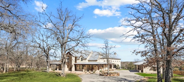 view of front of property featuring a gazebo, driveway, and a front lawn