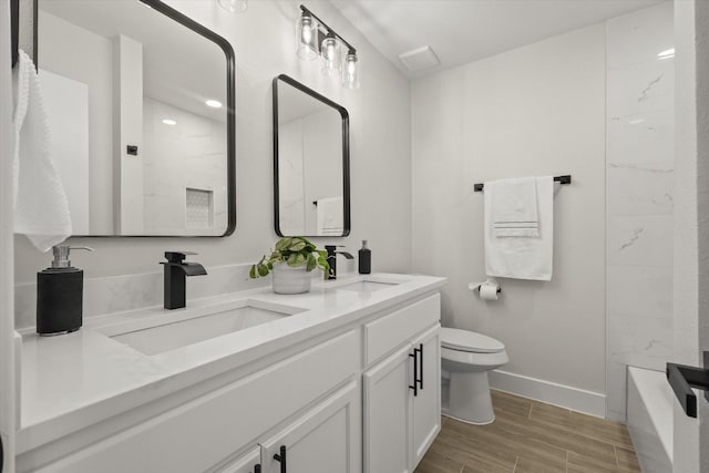 full bathroom featuring toilet, baseboards, a sink, and wood finish floors