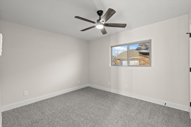 carpeted spare room with ceiling fan and baseboards