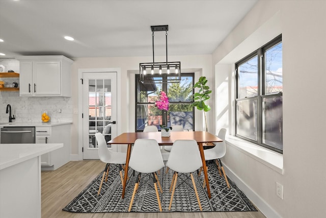 dining room featuring light wood-style floors, recessed lighting, and baseboards